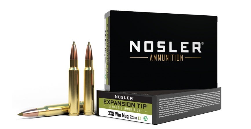 Box of Nosler 338 Win Mag ammo and three loose cartridges on white background