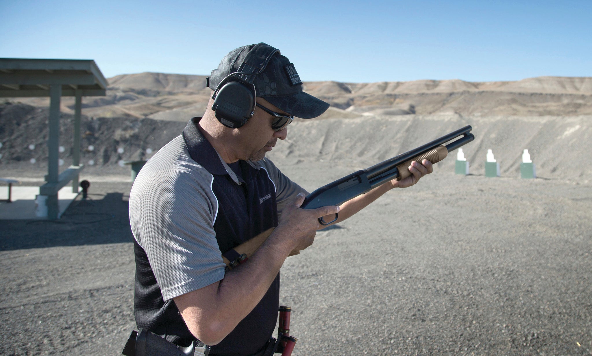 A shooter double-checks the action of his shotgun while on a shooting range