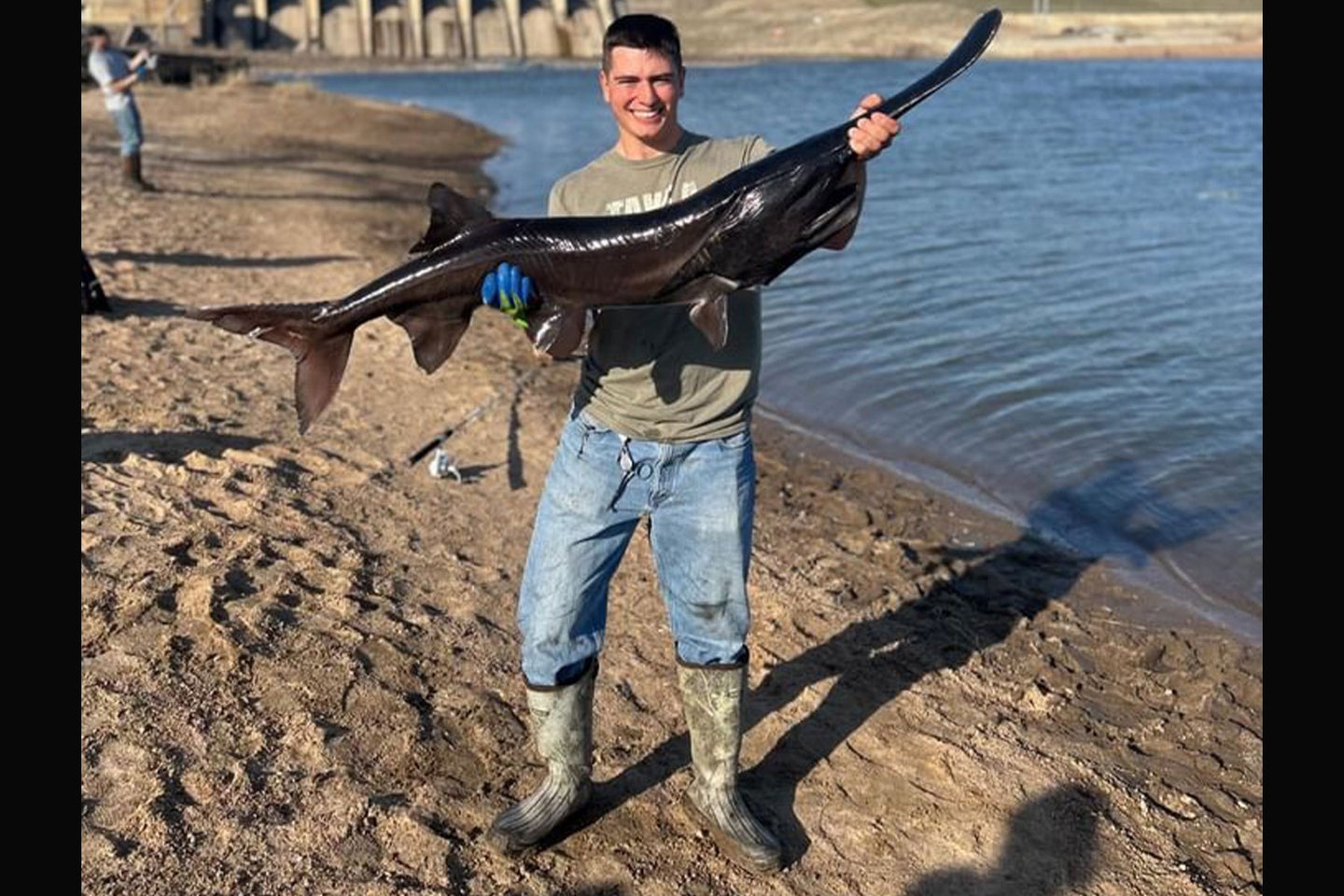 An Oklahoma angler poses with a rare black paddlefish.