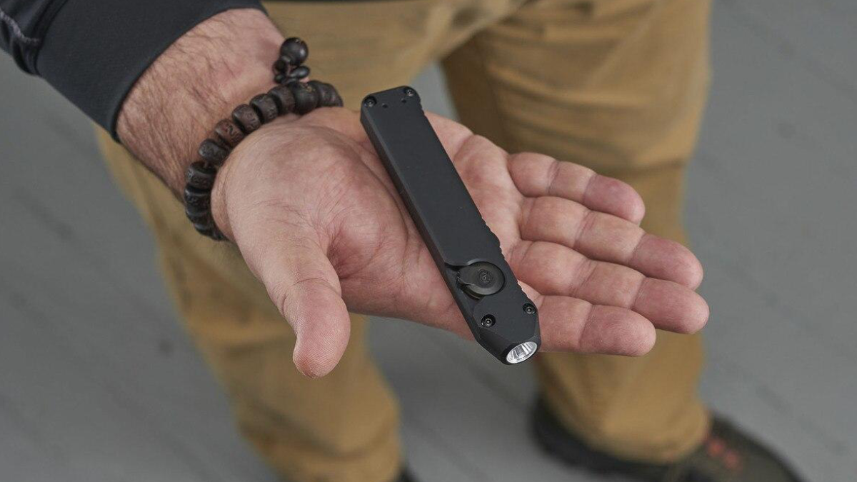 Close up of man holding Streamlight Wedge flashlight in his hand