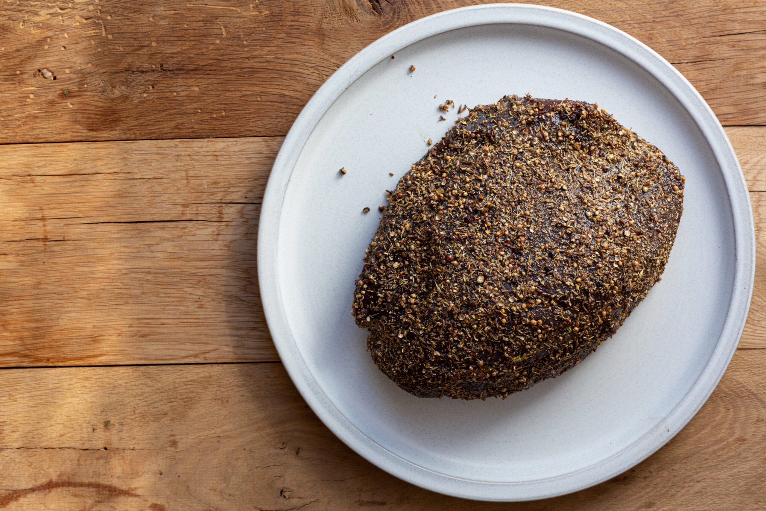 A venison roast covered in spices before it's made into venison pastrami.