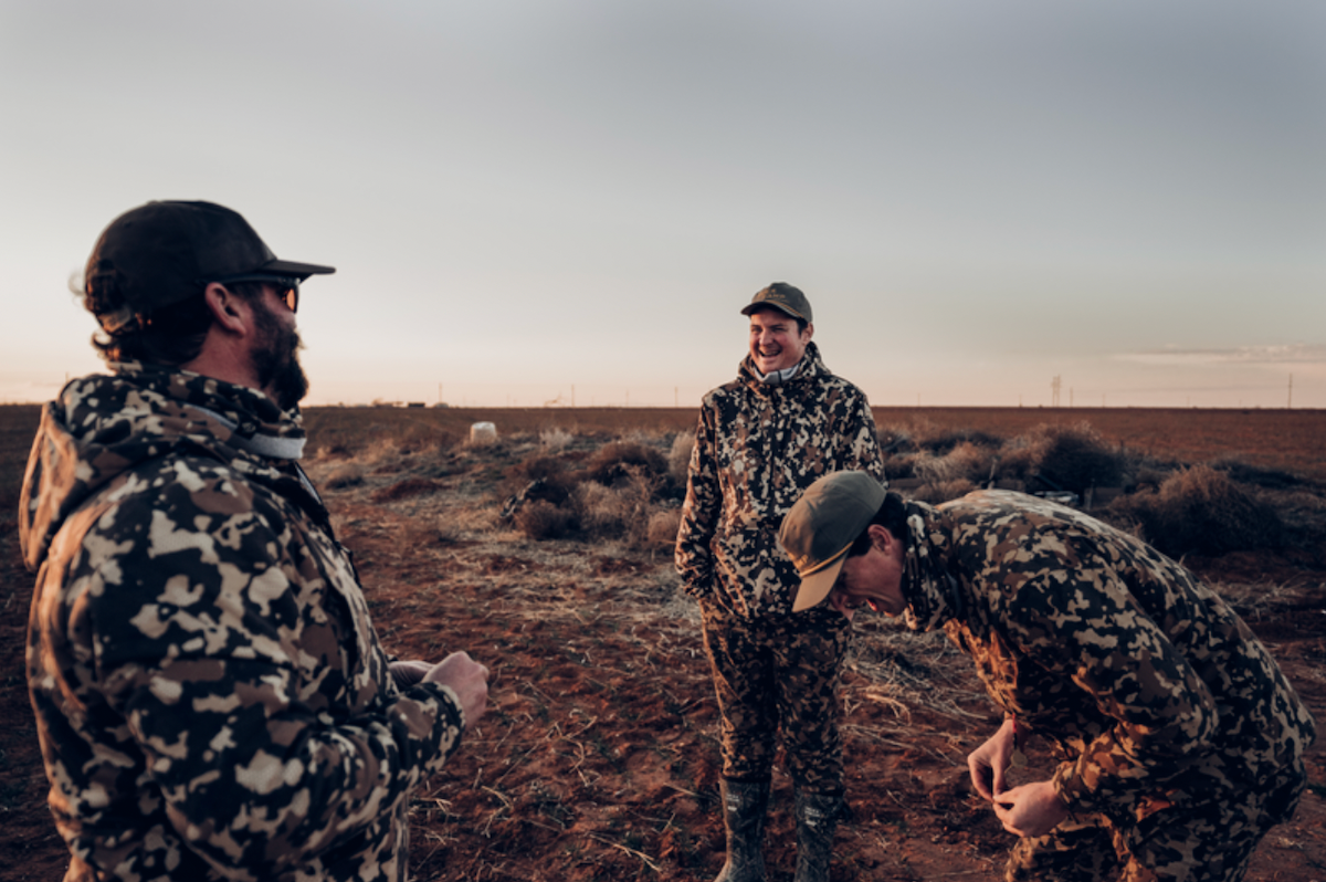 Three hunters talking and laughing wearing Duck Camp hunting gear