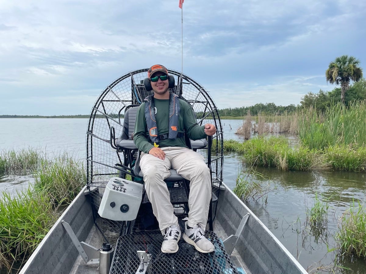 Angler sitting on fishing boat in Florida marsh wearing Columbia Silver Ridge convertible fishing pants