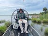 Angler sitting on fishing boat in Florida marsh wearing Columbia Silver Ridge convertible fishing pants