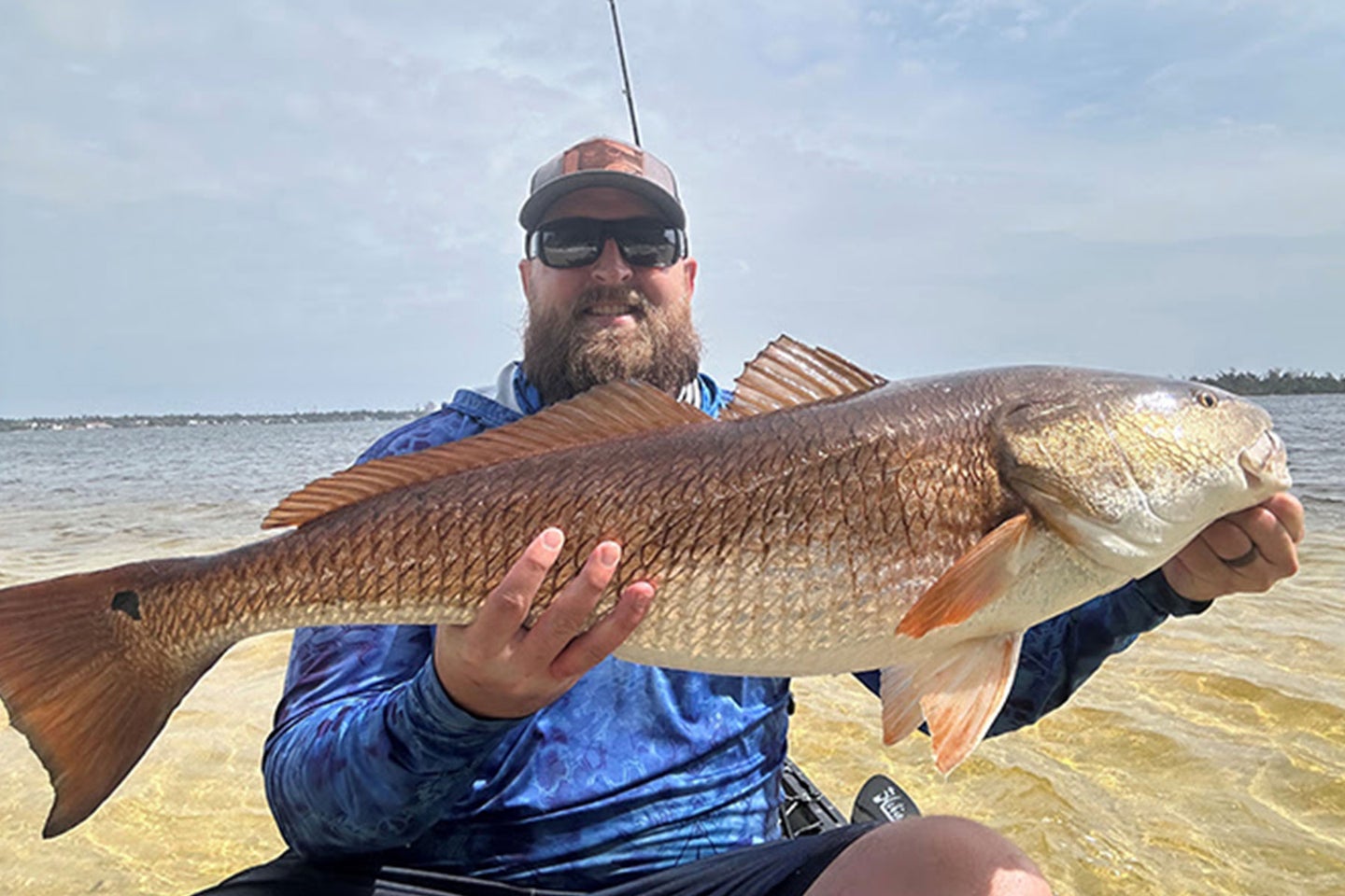 A Florida angler poses with a length-record redfish.