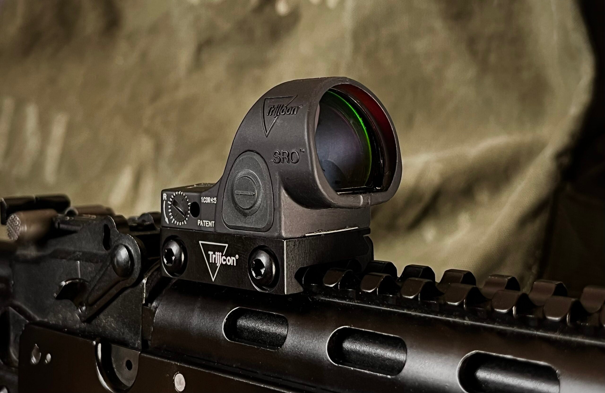 A Trijicon SRO red-dot sight mounted to a Picatinny rail on a Modern Sporting Rifle.