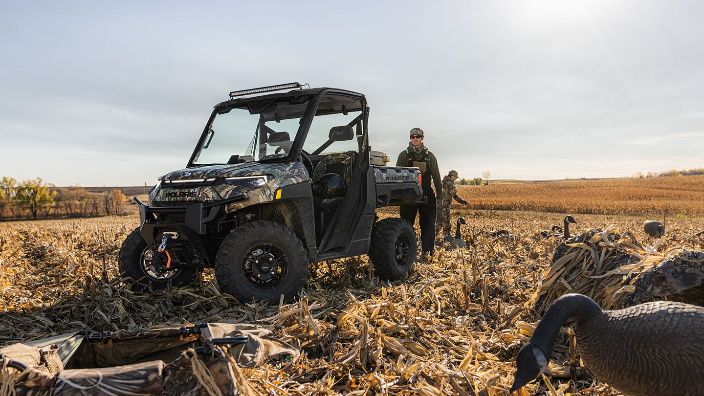 Waterfowl hunters drive a Polaris Ranger XP Kinetic UTV to the field to set up blinds and decoys