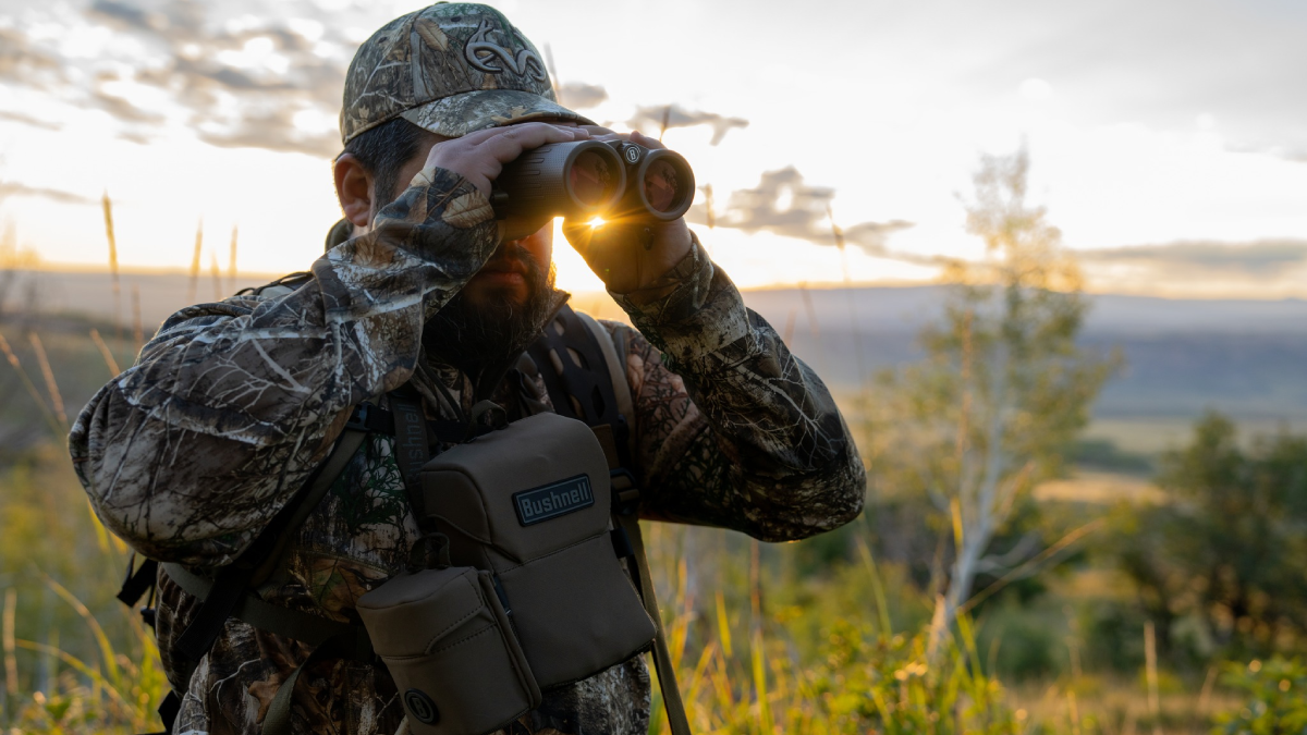 Hunter in the field looking through Bushnell binoculars