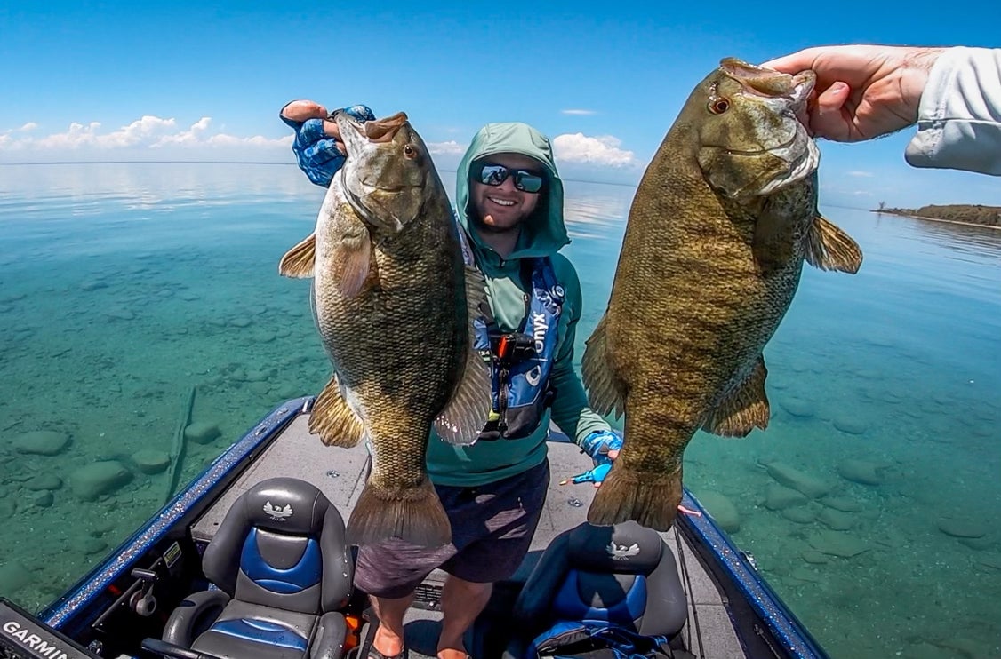 Bass anglers hold up a pair of big smallmouth bass on Lake Michigan.