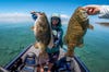 Bass anglers hold up a pair of big smallmouth bass on Lake Michigan.