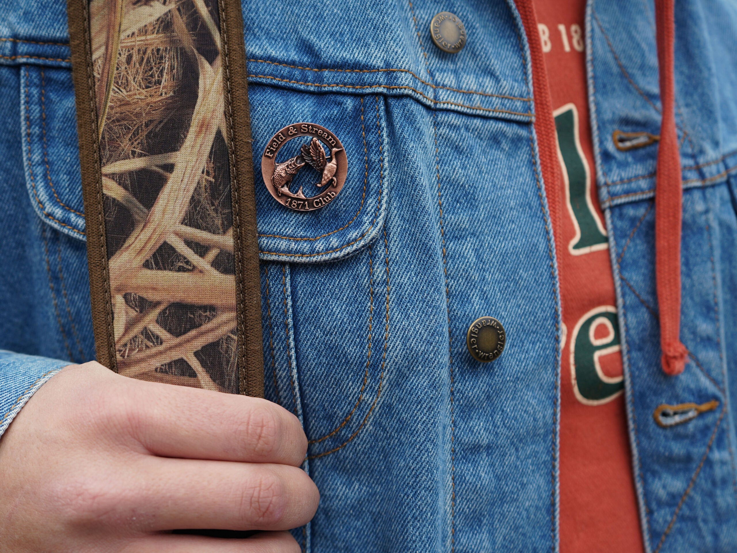 A Field & Stream honor badge pinned to a denim jacket