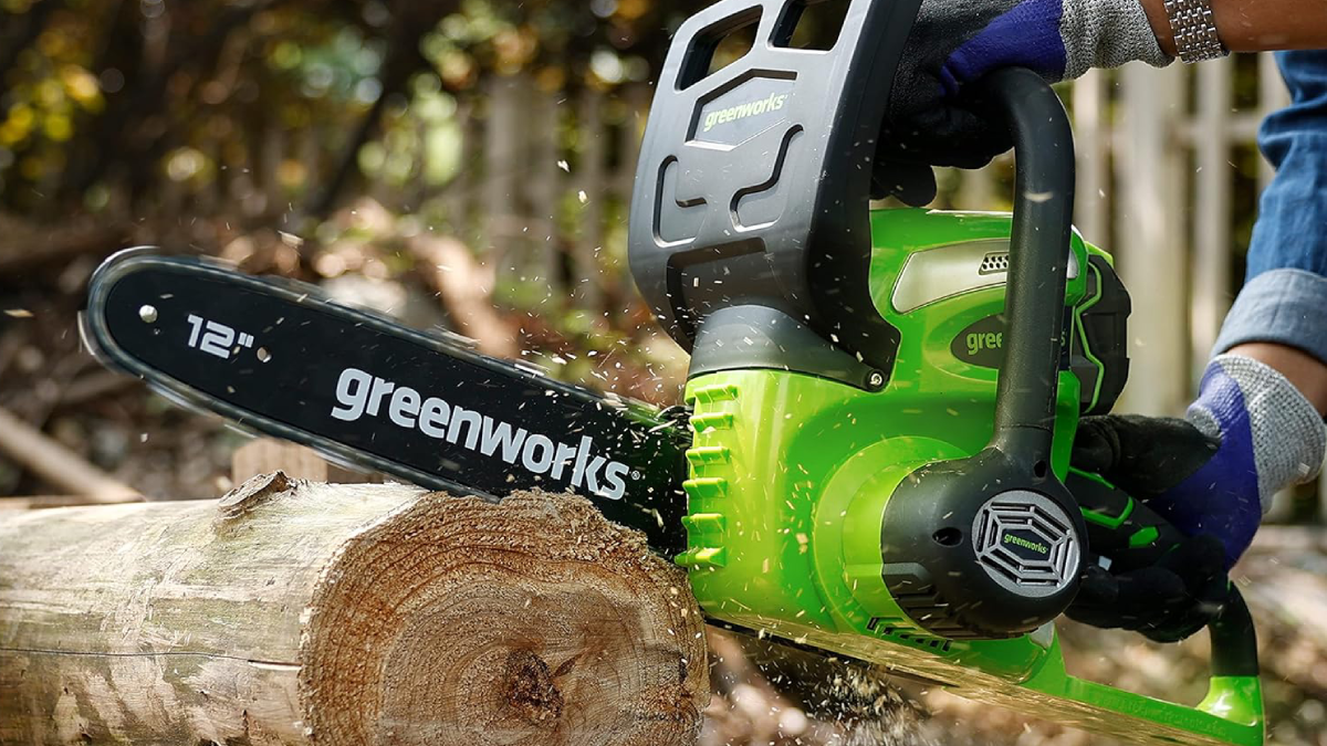 Man cutting tree with Greenworks electric chainsaw