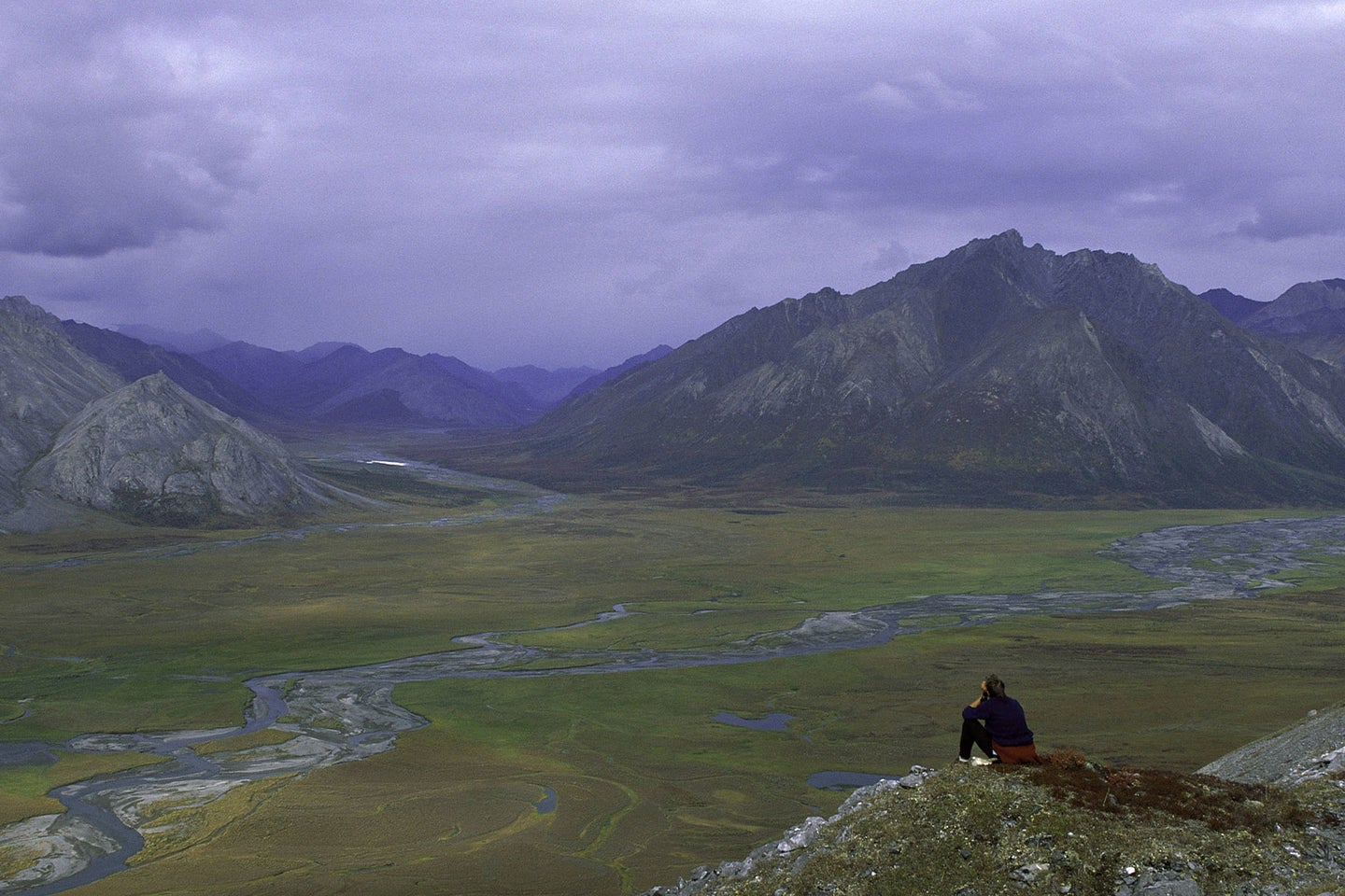 A person sits overlooking the Arctic National Wildlife Refuge in Alaska.