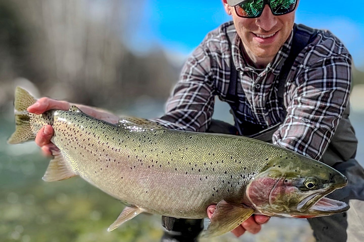 An angler poses with a state-record trout.
