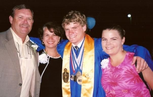 A family smiles at a high school graduation