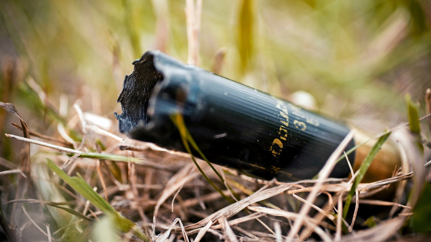 A fired turkey hunting shotgun shell lying on the ground.