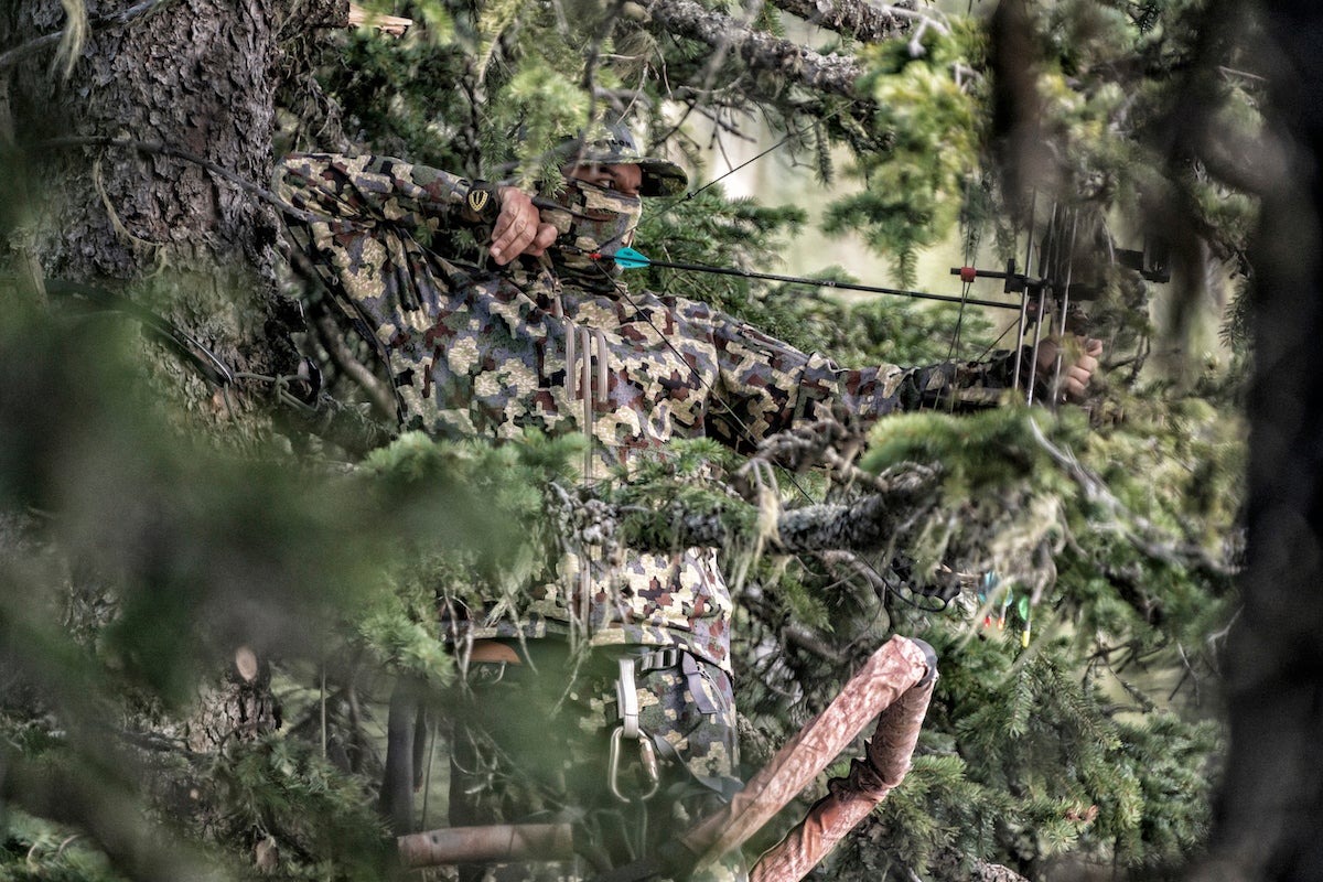 Bowhunter wearing Forloh soft shell jacket in tree stand