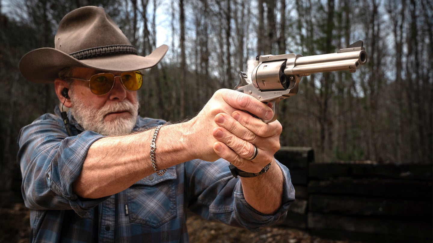 A shooter fires a revolver on the range, demonstrating the correct grip.